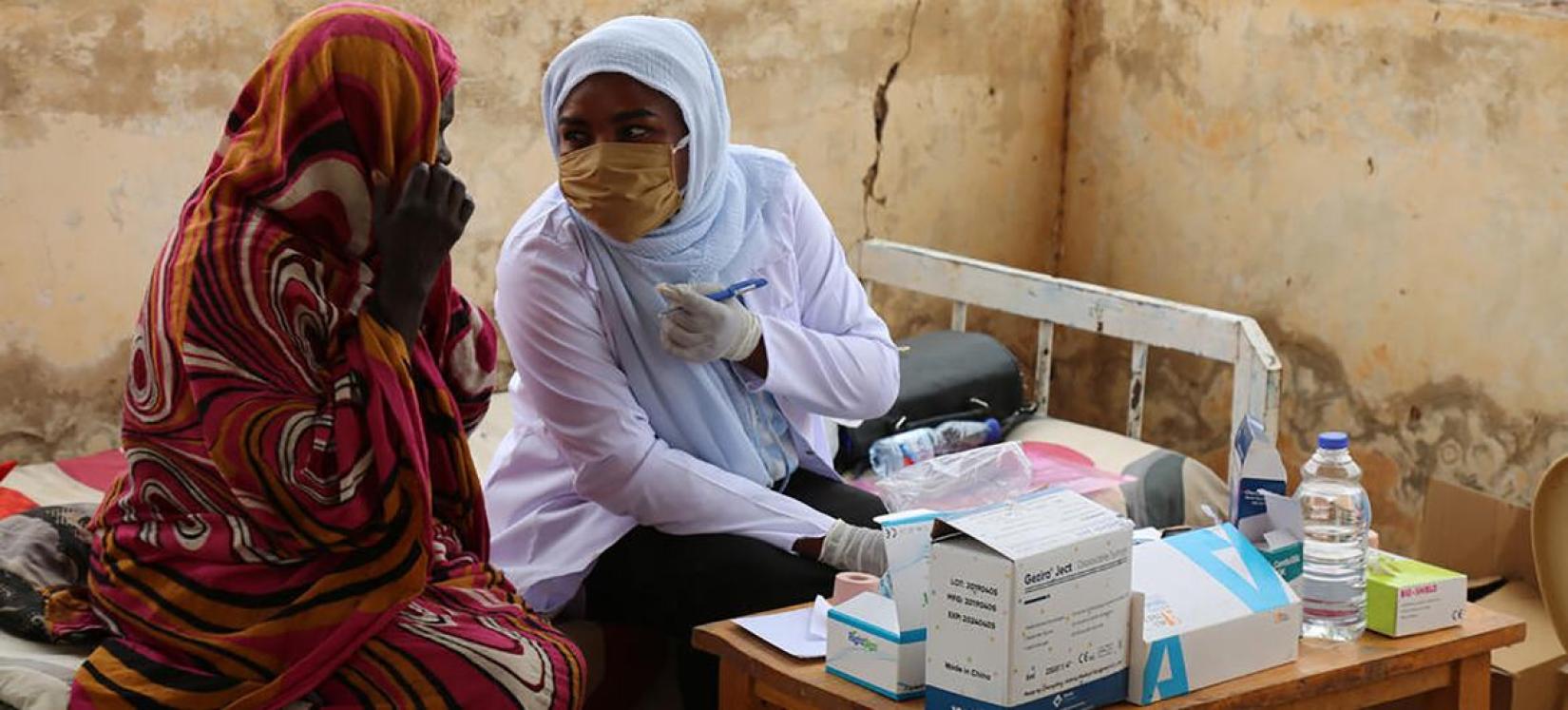Two midwives work at a UNFPA-supported clinic in Sudan.