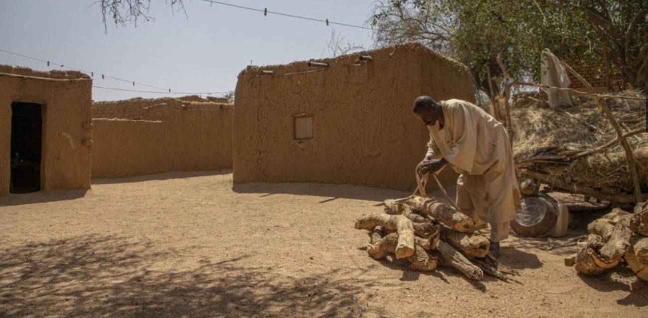 Ahmed Ishag Babiker, 54, piles up firewood in his compound in Kabkabiya in North Darfur, Sudan. He and his family were displaced when armed militias attacked his village in Wadi Bare in 2004.  © UNHCR/Will Swanson