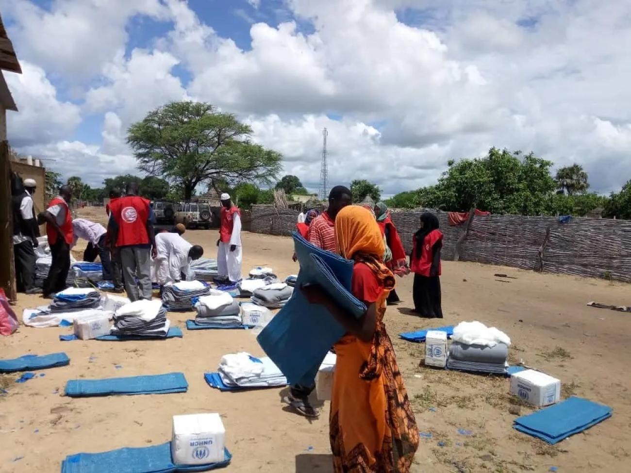Refugees and volunteers from the Sudanese Red Crescent Society (SRCS) supporting the distribution of humanitarian assistance in Um Dafoug, South Darfur