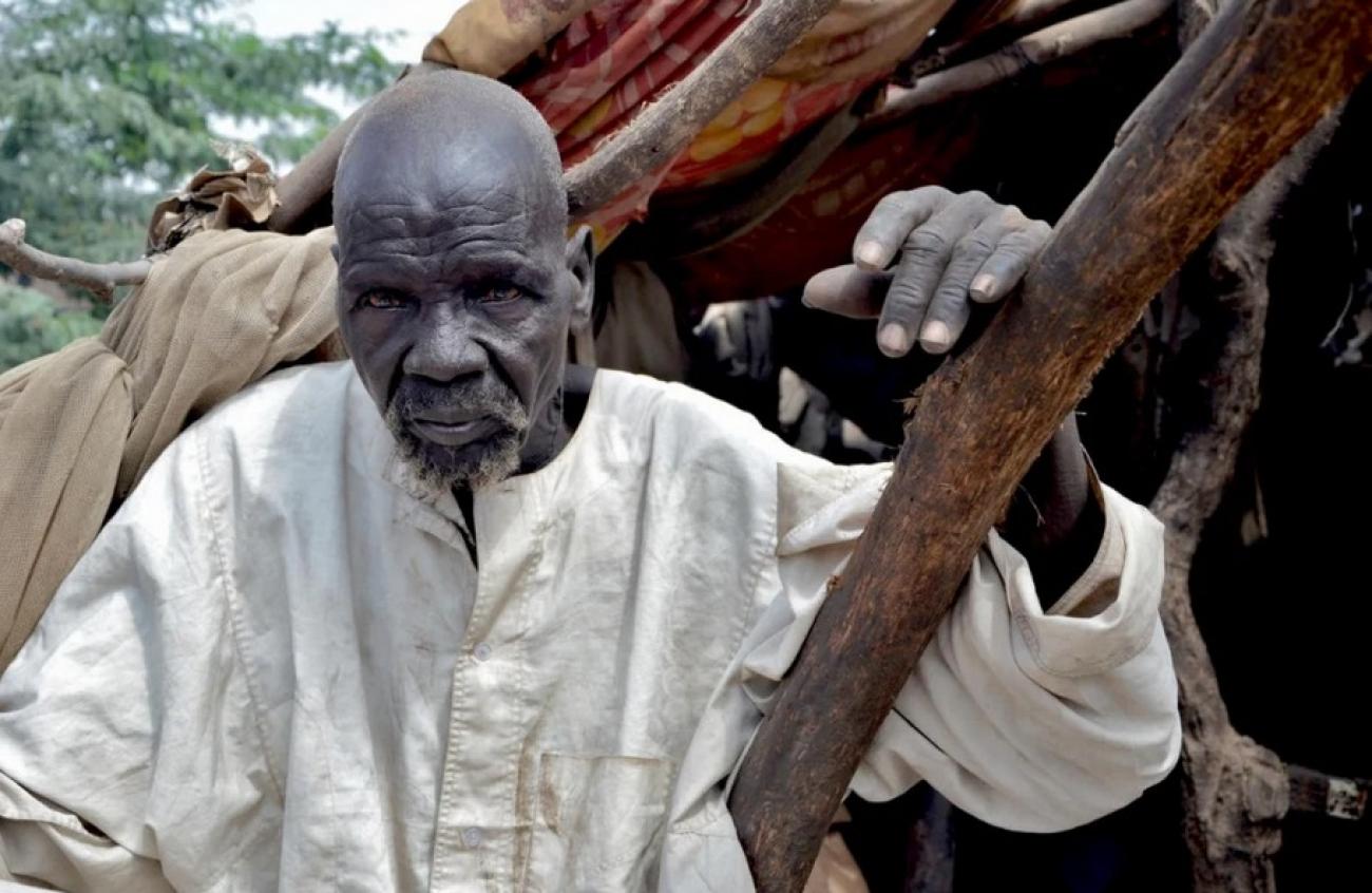 South Sudanese refugee, Bak, 80, sits in his shelter that was damaged by massive flooding in Sharq Al-Nile, Sudan.   © UNHCR/Roland Schönbauer